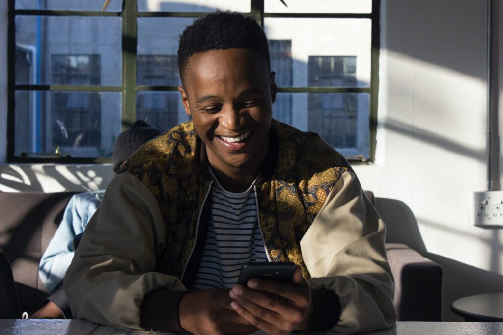 Man happily talking on her smartphone using Africallshop for international calls to Eritrea